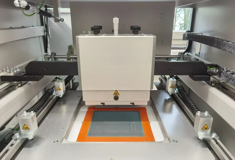Screen Printer This is a grey screen printer. It is open, allowing you to see the green screen and the squeegee holder.